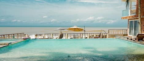 Een buitenzwembad, parasols voor strand/zwembad