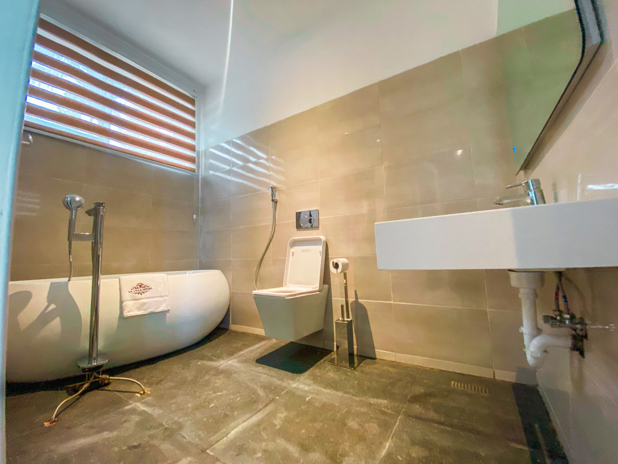 Ein modernes Badezimmer mit Badewanne, Toilette und Waschbecken.