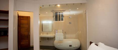 A modern bathroom with a glass-enclosed shower, a toilet, and a sink.