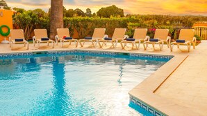 A poolside area with lounge chairs and a clear blue pool. - Peaceful villa with heatable pool in Galé (Albufeira)