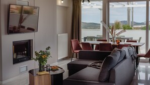 Ein modernes Wohnzimmer mit einer Couch, einem Esstisch und Stühlen. An der Wand ist ein Flachbildfernseher angebracht.