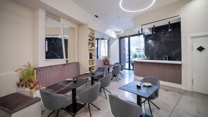 A modern dining area with a long table, multiple chairs, and a bar counter. - Mazzini Palace (Misterbianco)