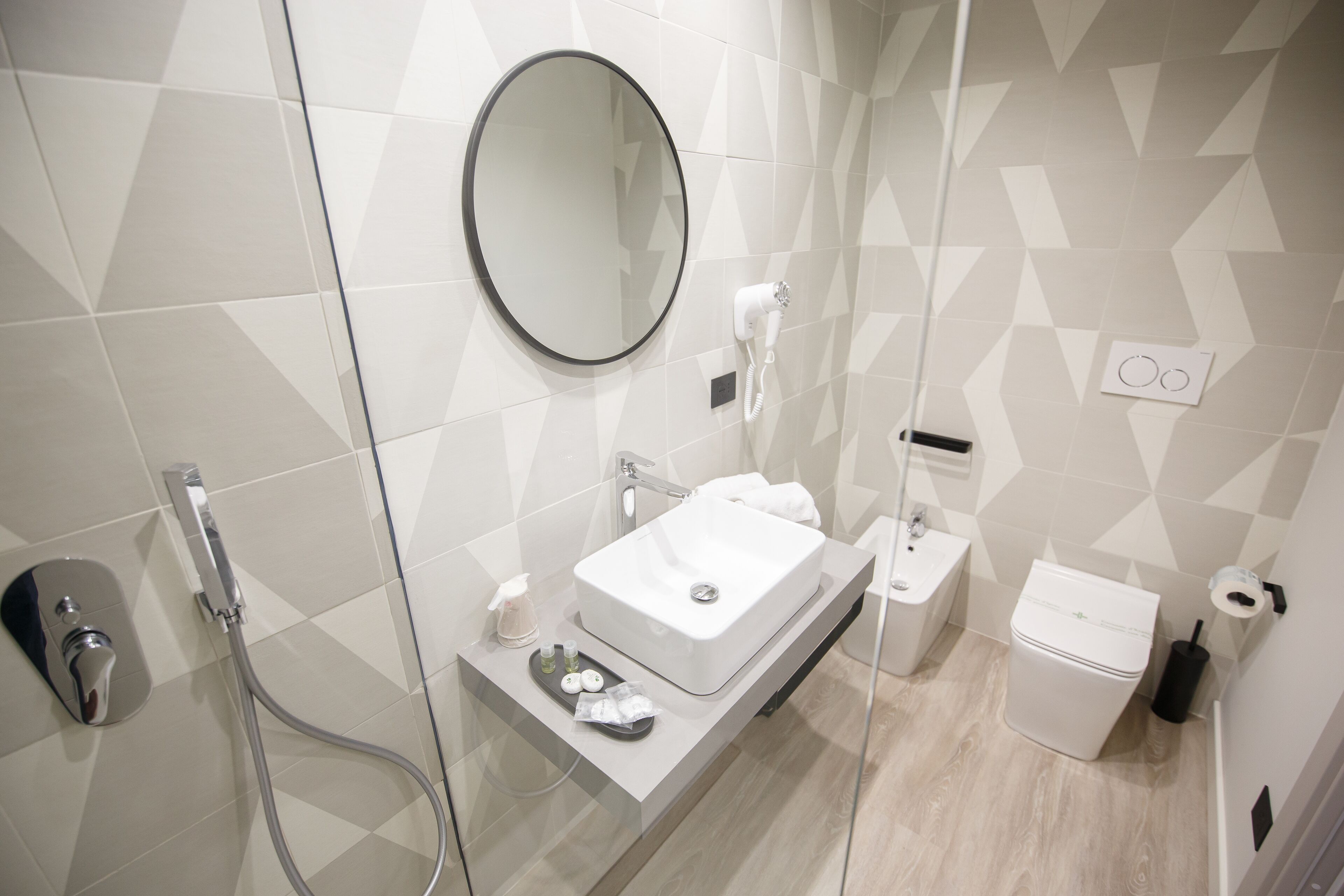 Une salle de bain moderne avec une douche à parois de verre, un lavabo blanc et des toilettes.