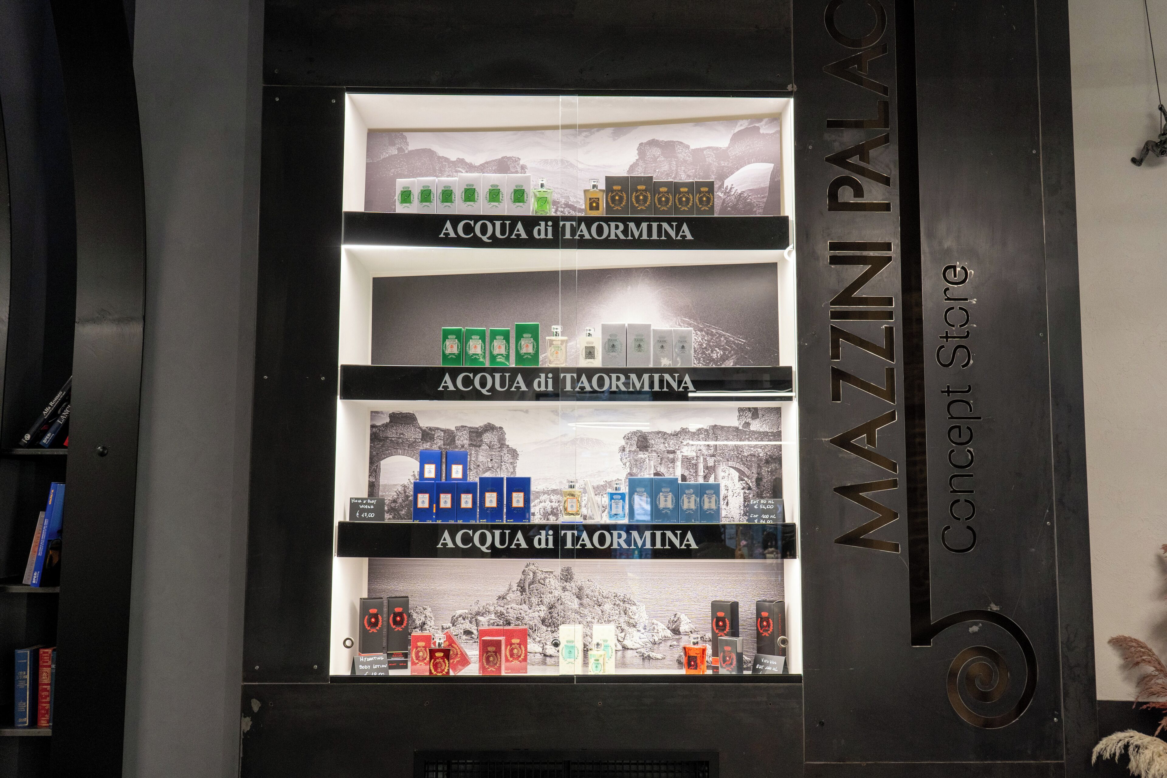 Ein Verkaufsregal mit mehreren Etagen voller ACQUA di TAORMINA Produkten.