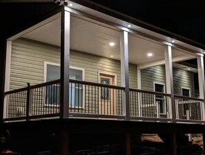 A two-story house with a covered porch and a fenced balcony. - Whispering Pines mountain home (Harrisonburg)