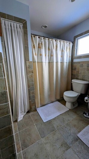 A bathroom with a shower curtain, toilet, and a window. - ONE block from the beach. Outdoor lounge seating, perfect for entertaining!  (Lavallette)