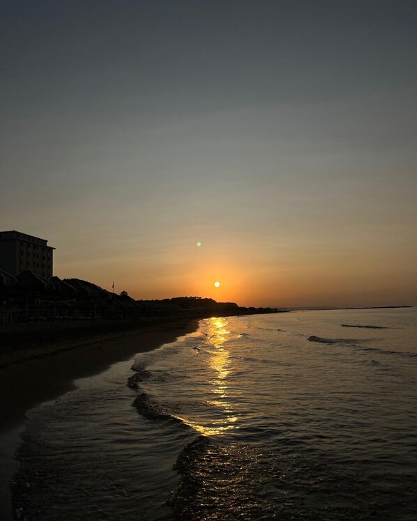 Playa privada, arena blanca y sombrillas