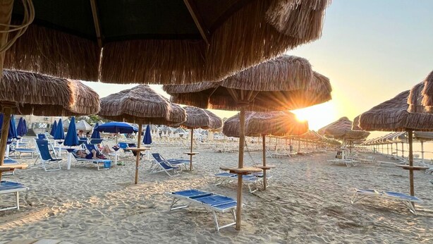 A beach with thatched umbrellas and lounge chairs. - Hotel Valente (Ortona)