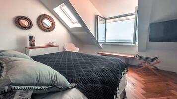 Ein Schlafzimmer mit Bett, Schreibtisch und Fenster.