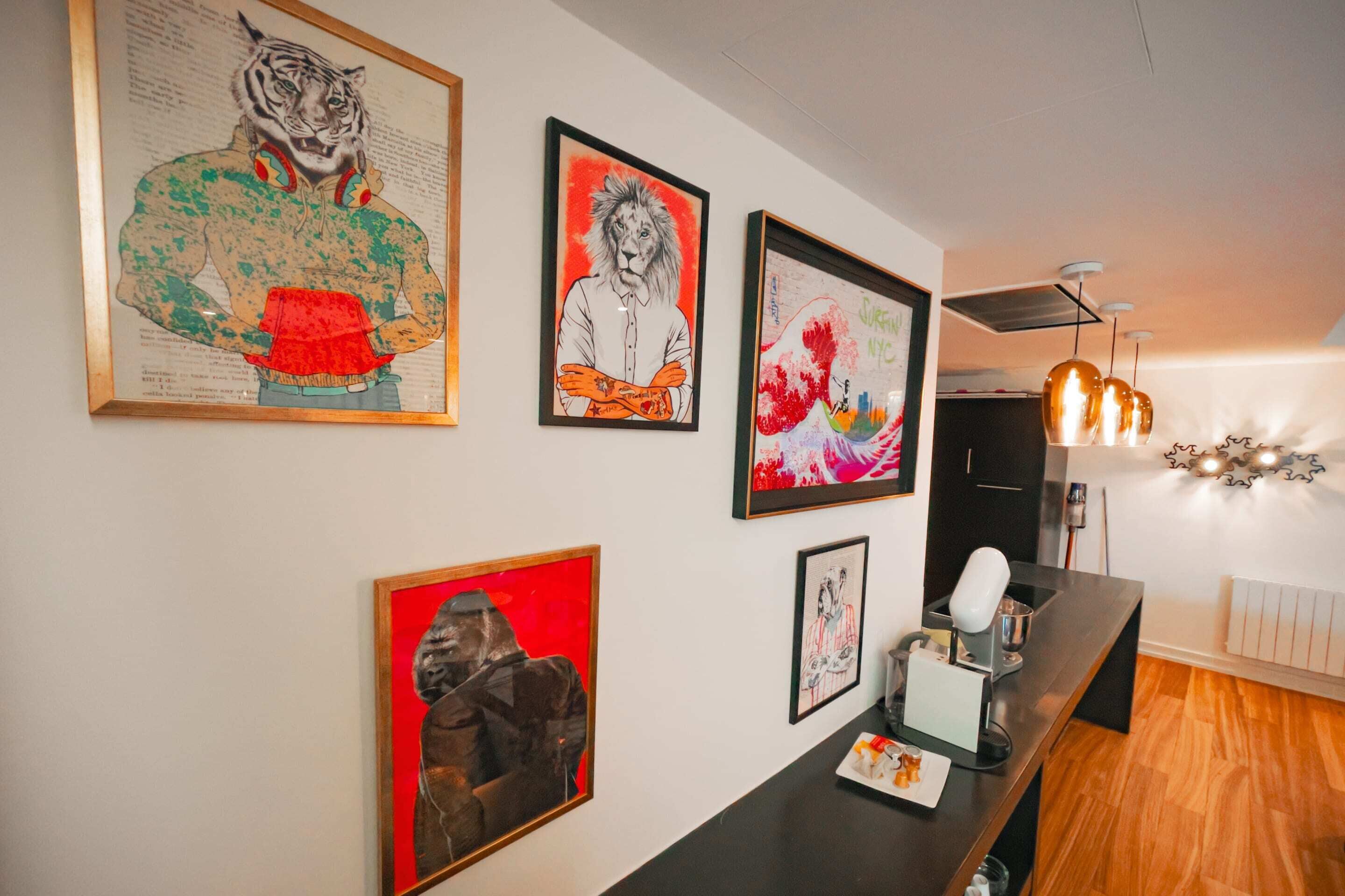 Ein modernes Interieur mit Kunstwerken an den Wänden, einem Holzbüro und einer Deckenleuchte.