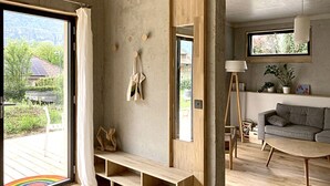 A modern living room with a wooden bench, a grey sofa, and a wooden coffee table. - Appartement Contemporain Avec Terrasse à 5mn de du lac D'annecy (Doussard)