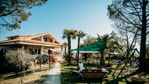 Ein Haus mit einer Terrasse, einer Schaukel und einem Weg zum Haus.