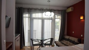 Een hotelkamer met een bed, bureau, stoel, bank en televisie.