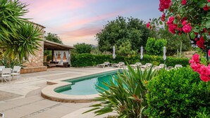A pool area with lounge chairs, a covered seating area, and lush greenery. - Quiet pool villa with chill out area, barbecue near Llucmajor, YourHouse Can Rosillo (LLucmajor)