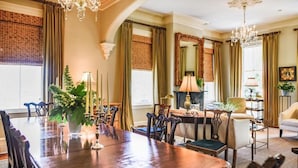 A formal dining room with a long wooden table, chairs, and a chandelier. - Catherine Ward House Inn (Savannah)
