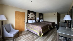 A hotel room with two beds, a desk, a chair, and a bathroom. - Harrington Welcome Inn (Harrington)