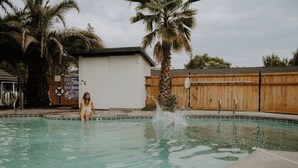 A swimming pool with a person sitting by the edge. - Triangle Motel (Red Bluff)