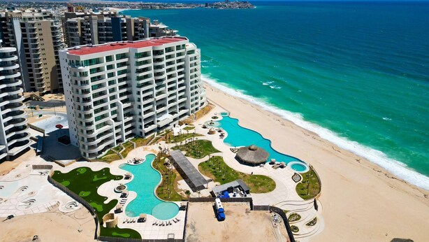 Un hôtel de grande hauteur doté d’une piscine et d’un accès à la plage.