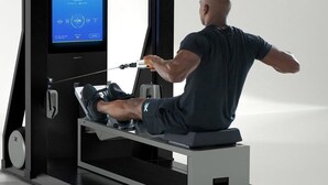 Ein Mann trainiert auf einem Rudergerät mit digitaler Anzeige.