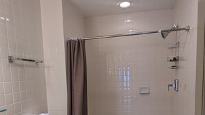 Ein Badezimmer mit Toilette, Waschbecken, Dusche und Fliesenwänden.