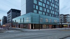 Un hôtel moderne, avec un logo bien visible, de grandes fenêtres et un toit plat.
