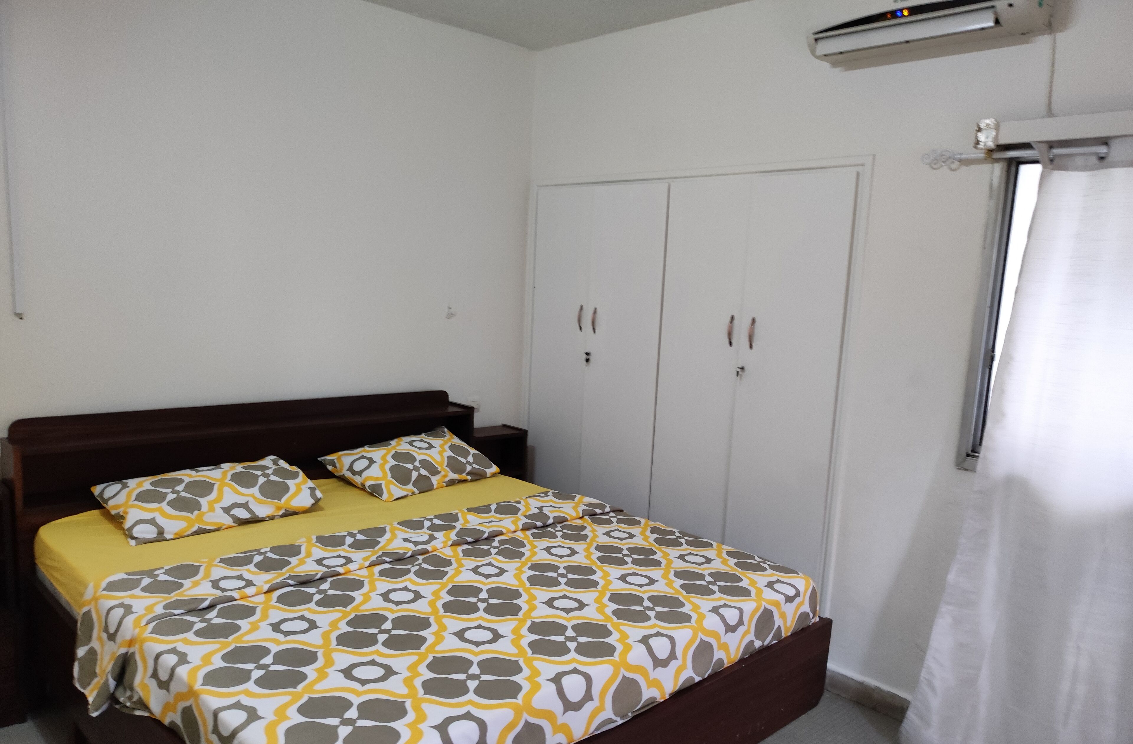 Una camera da letto con un letto, un armadio e una tenda.