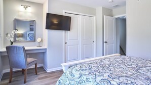 A bedroom with a bed, a desk with a chair, a TV mounted on the wall, and a wardrobe. - New Condo! Minutes from Sand Springs Golf Course & Wedding/Event Venue (Drums)