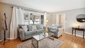 Ein Wohnzimmer mit grauem Sofa, Couchtisch und kleinen Beistelltisch.