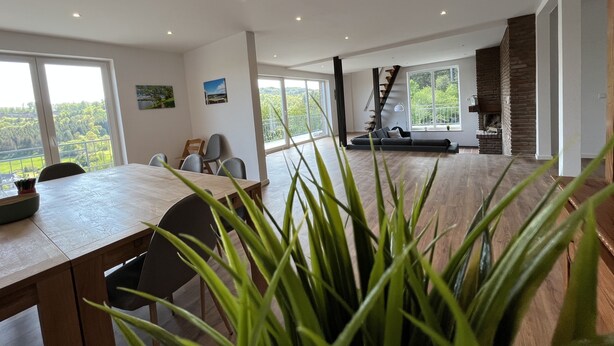 A spacious living area with a dining table, seating, a staircase, and a fireplace. - Traumaussicht, Traumwanderungen, Viel zu Entdecken und Richtig Viel Platz!! (Daun)