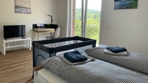 A bedroom with a bed, a desk, a TV, and a balcony with a view. - Traumaussicht, Traumwanderungen, Viel zu Entdecken und Richtig Viel Platz!! (Daun)