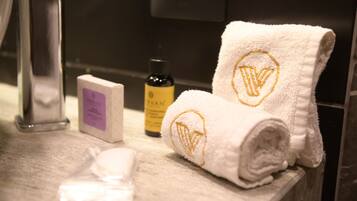 A bathroom with a white towel, a bottle of lotion, and a soap bar on the counter.