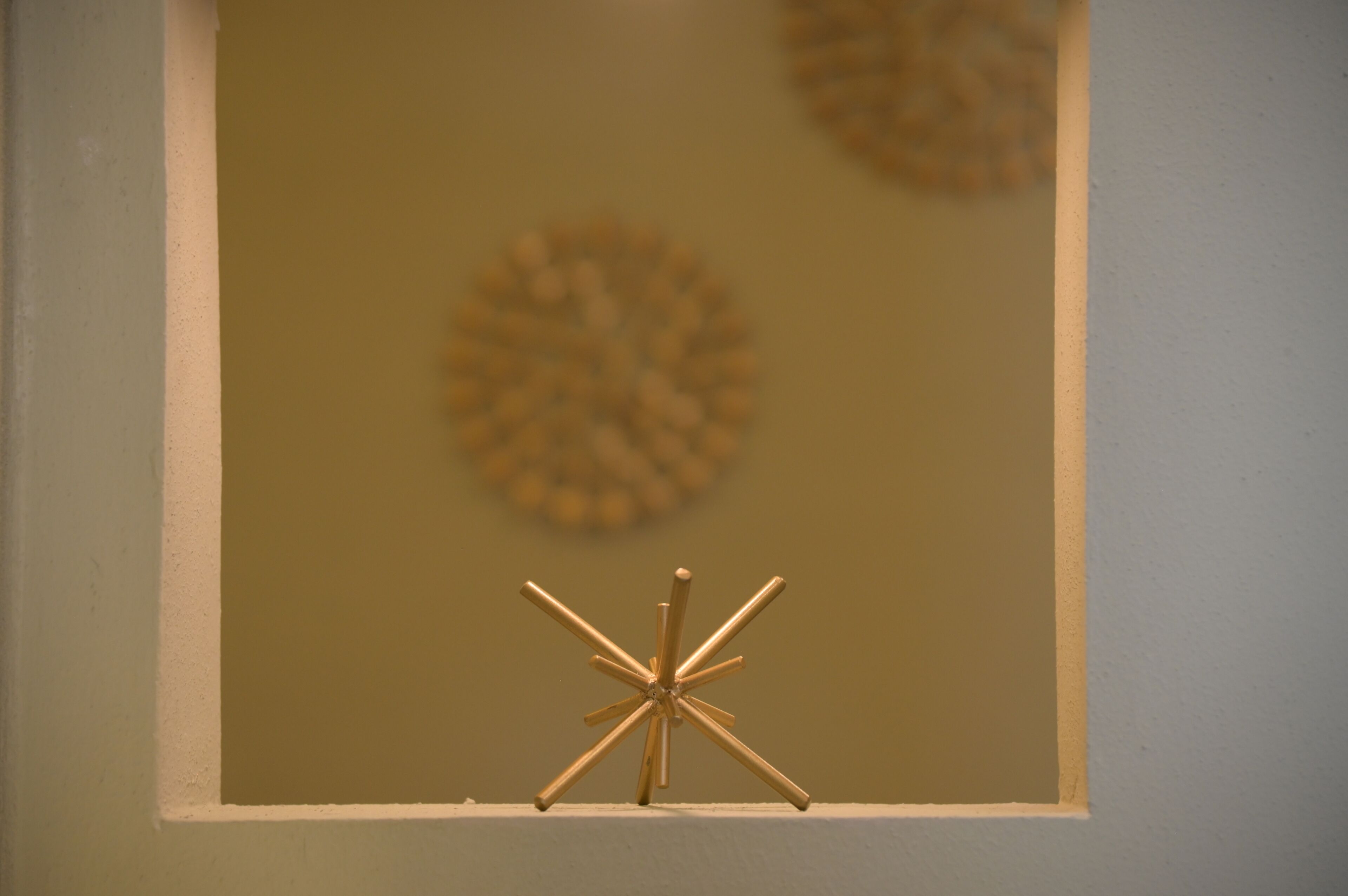Una obra de arte enmarco con un diseño similar a una estrella en una pared.