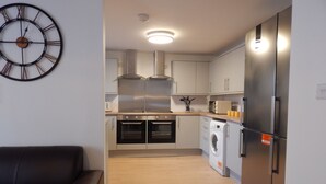 Eine kleine Küche mit Waschmaschine, Backofen und Mikrowelle.