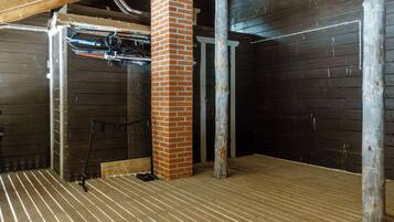 A room with a wooden floor, brick pillar, and metal beams.