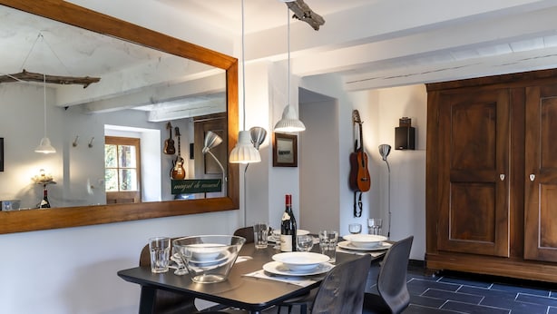 A dining area with a large mirror, wooden beams, and a rustic chandelier. - Grangettes by Interhome (Noville)