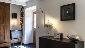 A modern interior with a wooden cabinet, a guitar, a framed artwork, and a wall-mounted lamp. - Grangettes by Interhome (Noville)