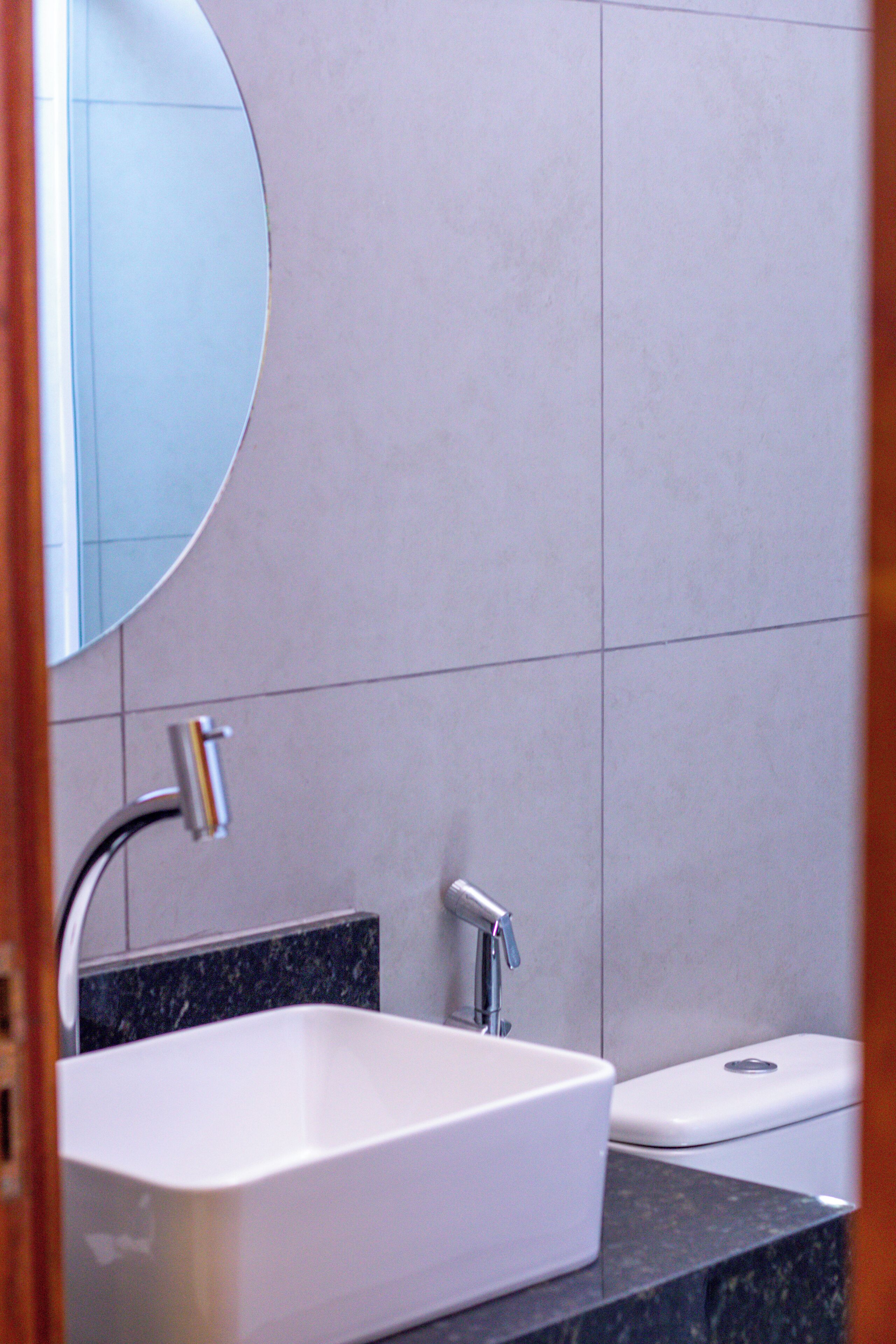 Een badkamer met een wit wastafel, een spiegel en een toilet.