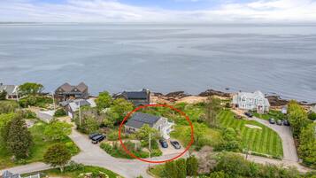 A coastal residential area with houses, a driveway, and a lawn.