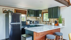 A modern kitchen with a large island, stainless steel appliances, and wooden accents. - Overlook Loft - Scenic Shenandoah Views (Elkton)