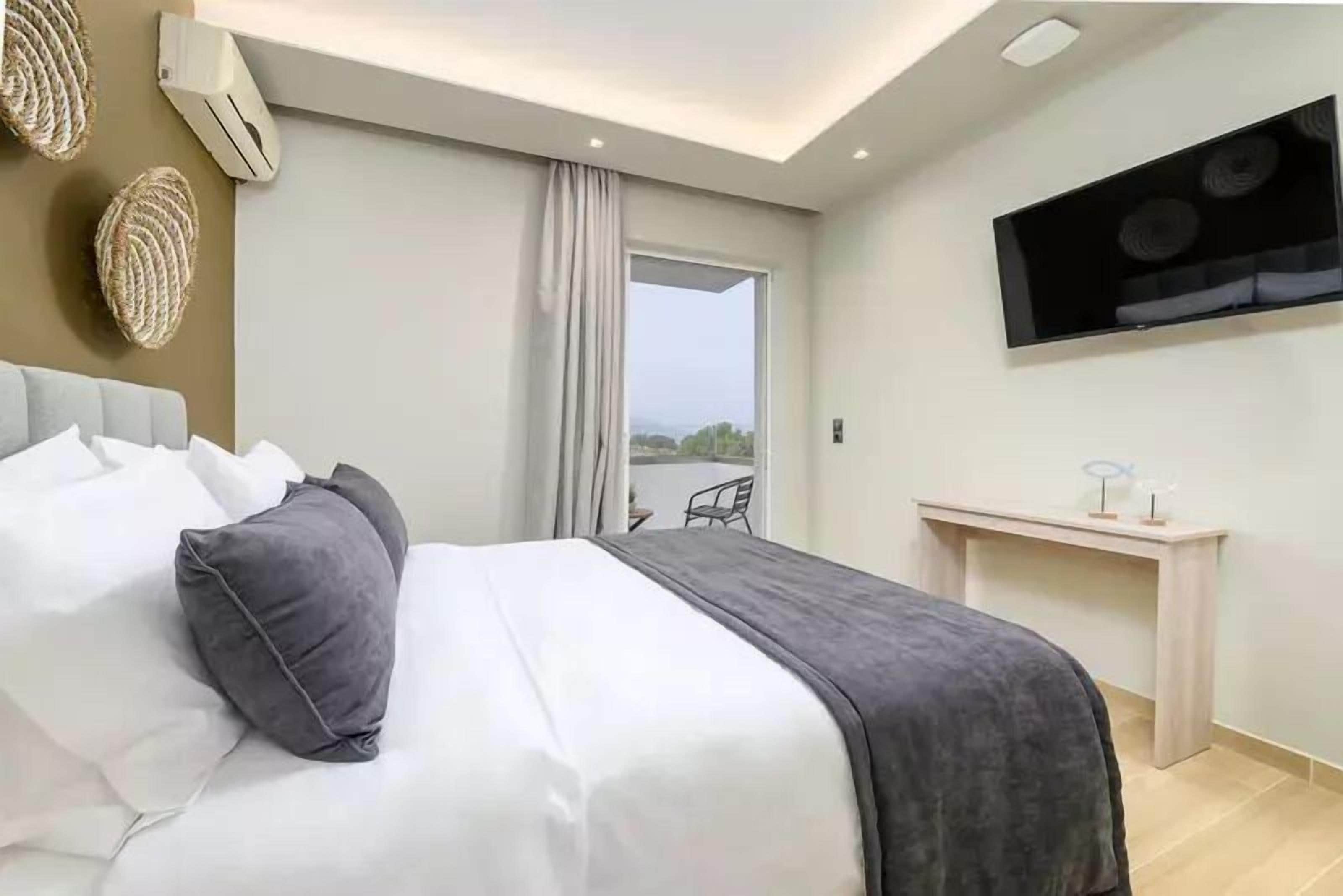 Quarto de hotel moderno com cama, escrivaninha e televisão.