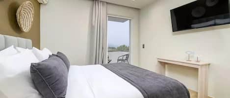 Una habitación de hotel moderna con una cama, un escritorio y un televisor.