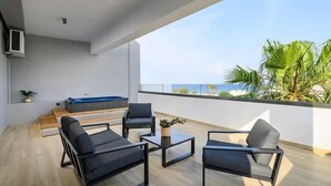 A modern balcony with a sofa, chairs, and a coffee table. - Nicolas Grand Suites - Adults Only (Kos)