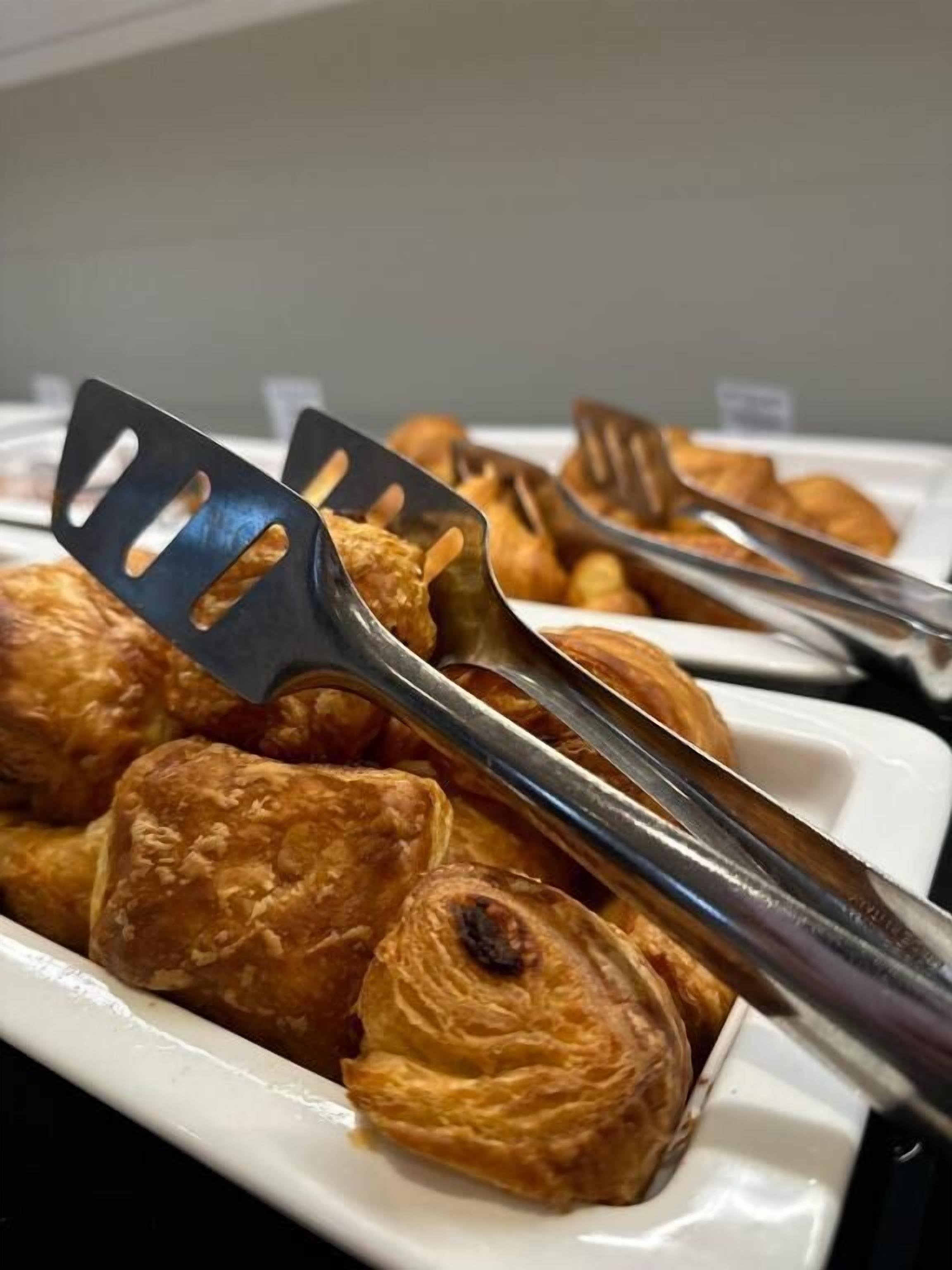 Una mesa de buffet con pasteles y pinzas.