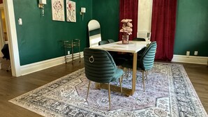 A dining area with a table, chairs, and a rug.