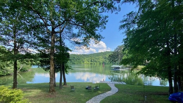 Un sendero junto al lago con bancos y un muelle que se adentra en el agua.