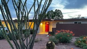 A modern house with a red door, surrounded by a garden with cacti and flowers. - Desert Oasis w/Pool & Spa Close to Saguaro National Park (Tucson)