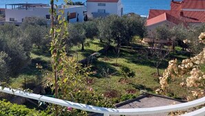 Une zone résidentielle côtière, avec des maisons, une vue dégagée sur la mer et un paysage vallonné à l’horizon.