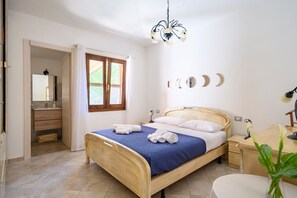 Une chambre à coucher avec un lit, une table de chevet, une lampe et un miroir.