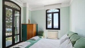 A bedroom with a bed, a window, a radiator, and a view of the outdoors. - Villa 'Capriccio' with Sea View, Private Terrace and Private Garden (Bordighera)
