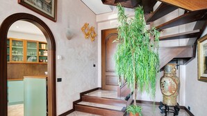 A staircase with wooden steps, a green plant, and a decorative vase. - Villa 'Capriccio' with Sea View, Private Terrace and Private Garden (Bordighera)
